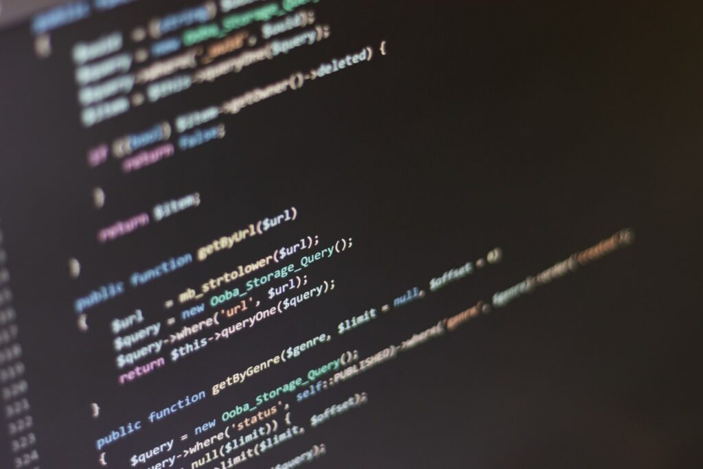 Close-up of PHP source code on a dark screen, showing function definitions and database query calls